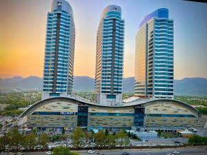 a group of tall buildings in a city at Guest Nest Executive Stay- Elysium Tower Opposite Centaurus Mall Islamabad in Islamabad