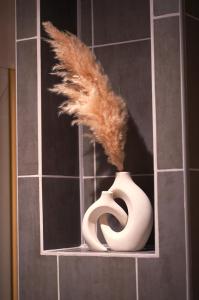 a feather sticking out of a toilet in a bathroom at Lunéa - Suite Premium avec Spa et Sauna in Dompierre-sur-Besbre