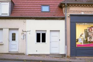 a white building with a blue door and a window at Lunéa - Suite Premium avec Spa et Sauna in Dompierre-sur-Besbre