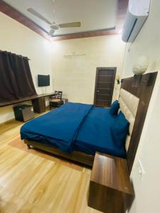 um quarto com uma cama azul em um quarto em Hotel White affordable Stay - Near Taj em Agra