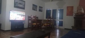 a living room with a television and a table and chairs at Cabo house in Cabo Negro
