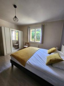 ein Schlafzimmer mit einem großen Bett und zwei Fenstern in der Unterkunft La Galina in Saint-André-dʼAllas