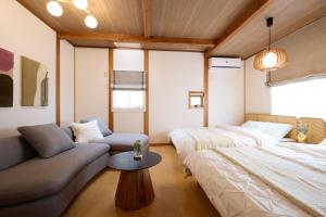 a bedroom with a bed and a couch and a table at casa de tsuru in Osaka