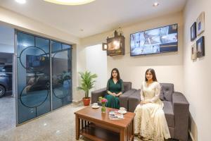 two women sitting on a couch in a living room at Hotel Rock View in New Delhi