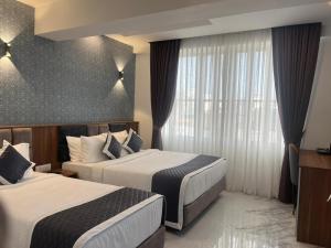 a hotel room with two beds and a window at SABU's GRAND ROYALE HOTEL in Trivandrum