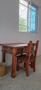 ein Holztisch mit einer Bank und einem Fenster in der Unterkunft Furali'Sa in Paje