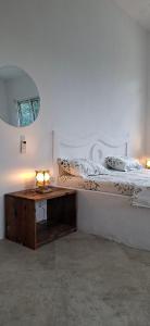 Schlafzimmer mit einem Bett mit einem Tisch und einem Spiegel in der Unterkunft Furali'Sa in Paje