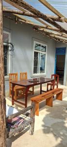 einem Holztisch und Bänken vor einem Haus in der Unterkunft Furali'Sa in Paje