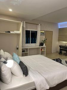 a bedroom with a large bed with white sheets and pillows at Rural stay Baan mea pen in Ban Pang Mung