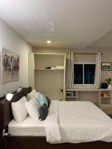 ein Schlafzimmer mit einem Bett mit weißen Laken und Kissen in der Unterkunft Rural stay Baan mea pen in Ban Pang Mung