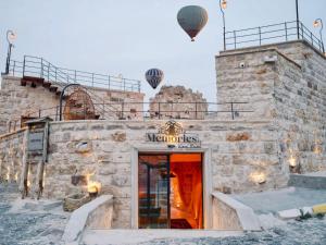 a building with two hot air balloons in the sky at Memories Cave House in Uçhisar