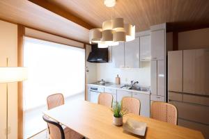 a kitchen with a wooden table and chairs and a dining room at casa de tsuru in Osaka