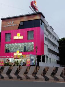 un edificio rosa con un cartel encima en ssr grand residency, en Padappai