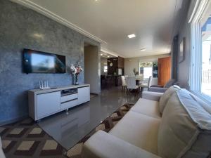 Μια τηλεόραση ή/και κέντρο ψυχαγωγίας στο Casa Com Três Dormitórios Pertinho Do Mar Em Capão Da Canoa