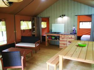a living room with a table and a kitchen at Domaine fontaine du roc in Dévillac
