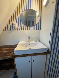 ein Badezimmer mit einem weißen Waschbecken und einem Spiegel in der Unterkunft Sofort am Strand! in Kiel + 32 Fotos