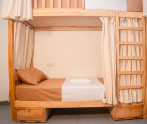 Etagenbett in einem Zimmer mit einer Leiter in der Unterkunft Soluna Hostel in Ahangama