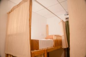 ein Bett in einem Zimmer mit einem Vorhang in der Unterkunft Soluna Hostel in Ahangama + 2 Fotos
