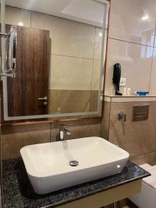 a bathroom with a white sink and a mirror at SABU's GRAND ROYALE HOTEL in Trivandrum
