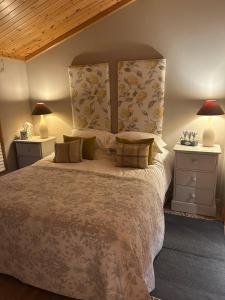 une chambre avec un grand lit et deux tables de nuit dans l'établissement The Boathouse Lodge, à Whelford