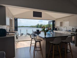 une cuisine avec une grande vue sur l'eau dans l'établissement The Boathouse Lodge, à Whelford