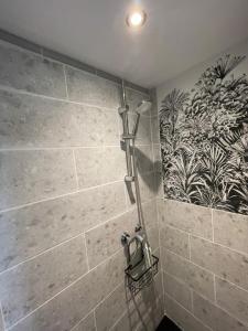 une douche dans une salle de bain avec un mur carrelé dans l'établissement Famille LATT, à Ouges 12 autres photos