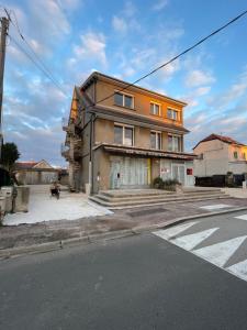 un bâtiment orange au coin d'une rue dans l'établissement Famille LATT, à Ouges