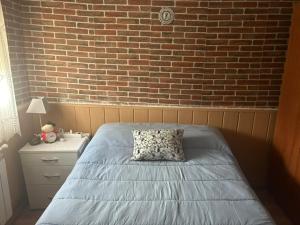 a bedroom with a bed and a brick wall at Casa Rural en BRAÑOSERA in Brañosera