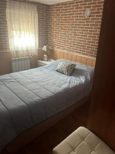 a bedroom with a bed and a brick wall at Casa Rural en BRAÑOSERA in Brañosera