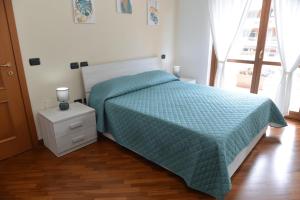 a bedroom with a bed with a blue comforter at Luciana Apt - 3 min train to FCO Airport & Fiera in Fiumicino
