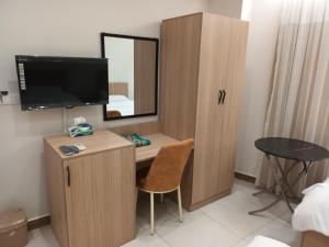 Habitación con escritorio con espejo y TV. en aran hotel, en Duhok