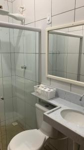 ein Badezimmer mit Toilette, Waschbecken und Spiegel in der Unterkunft Casa Maria Bonita in Maragogi