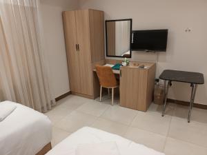 Una habitación de hotel con un escritorio, una cama y un televisor. en aran hotel, en Duhok