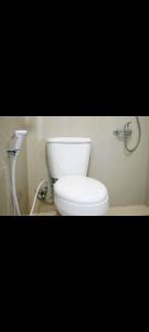 Un baño con un inodoro blanco en una habitación. en Easy staycation, en Rampal