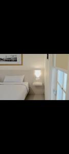 Una habitación blanca con una cama y una ventana en Easy staycation, en Rampal