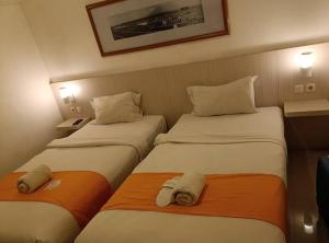 two beds in a hotel room with towels at Easy staycation in Rampal