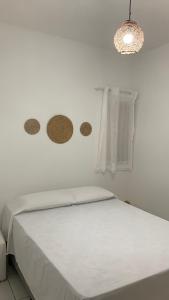 ein weißes Schlafzimmer mit einem Bett mit einer weißen Tagesdecke in der Unterkunft Casa Maria Bonita in Maragogi