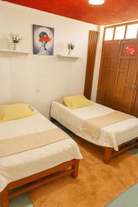 a room with two beds and a door at Departamento amoblado en primer piso 200 MTS a tu disposición con todos los servicios in Tacna