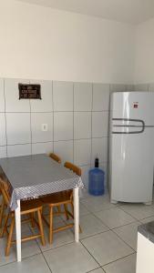 eine Küche mit Tisch und Kühlschrank in der Unterkunft Casa Maria Bonita in Maragogi