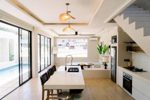 eine Küche und ein Esszimmer mit einem Tisch und einem Pool in der Unterkunft Stylish Canggu Villa 4BR with Ricefield View in Mantaak