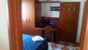 ローマにあるFiliberto Apartmentのベッド、デスク、鏡が備わる小さな客室です。
