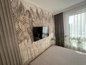 a bedroom with a wall with a tv on it at Classic&Modern Suite in Kętrzyn