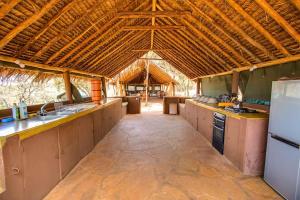 a large kitchen with counters and a large ceiling at Private bush camp with pool cottages tents - 2332 in Ilbisil