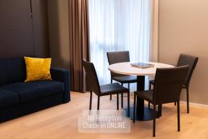 a dining room with a table and chairs and a couch at Arbed Living Hotel SELF CHECK IN - Supercharger - Fitness Bellinzona in Bellinzona