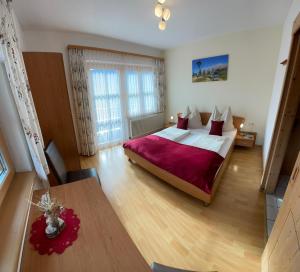 Un dormitorio con una cama grande y una mesa. en Bauernhof Bachgut, en Mühlbach am Hochkönig