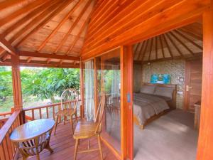 Lajolla Waterfall Resort في Luk: غرفة بسرير وطاولة على سطح السفينة