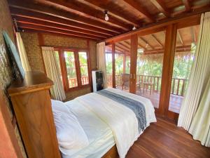 Lajolla Waterfall Resort في Luk: غرفة نوم بسرير في غرفة مع شرفة +7 صور