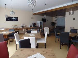 多瑙沃特的住宿－Hotel M&S garni，用餐室配有木桌和椅子