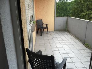 - un balcon avec deux chaises, une table et des chaises dans l'établissement Hotel M&S garni, à Donauwörth