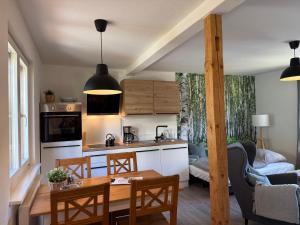 une cuisine et un salon avec une table et des chaises dans l'établissement Ferienhäusel Allemühl, à Schönbrunn